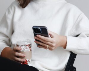 woman who is holding a apple phone scrolling